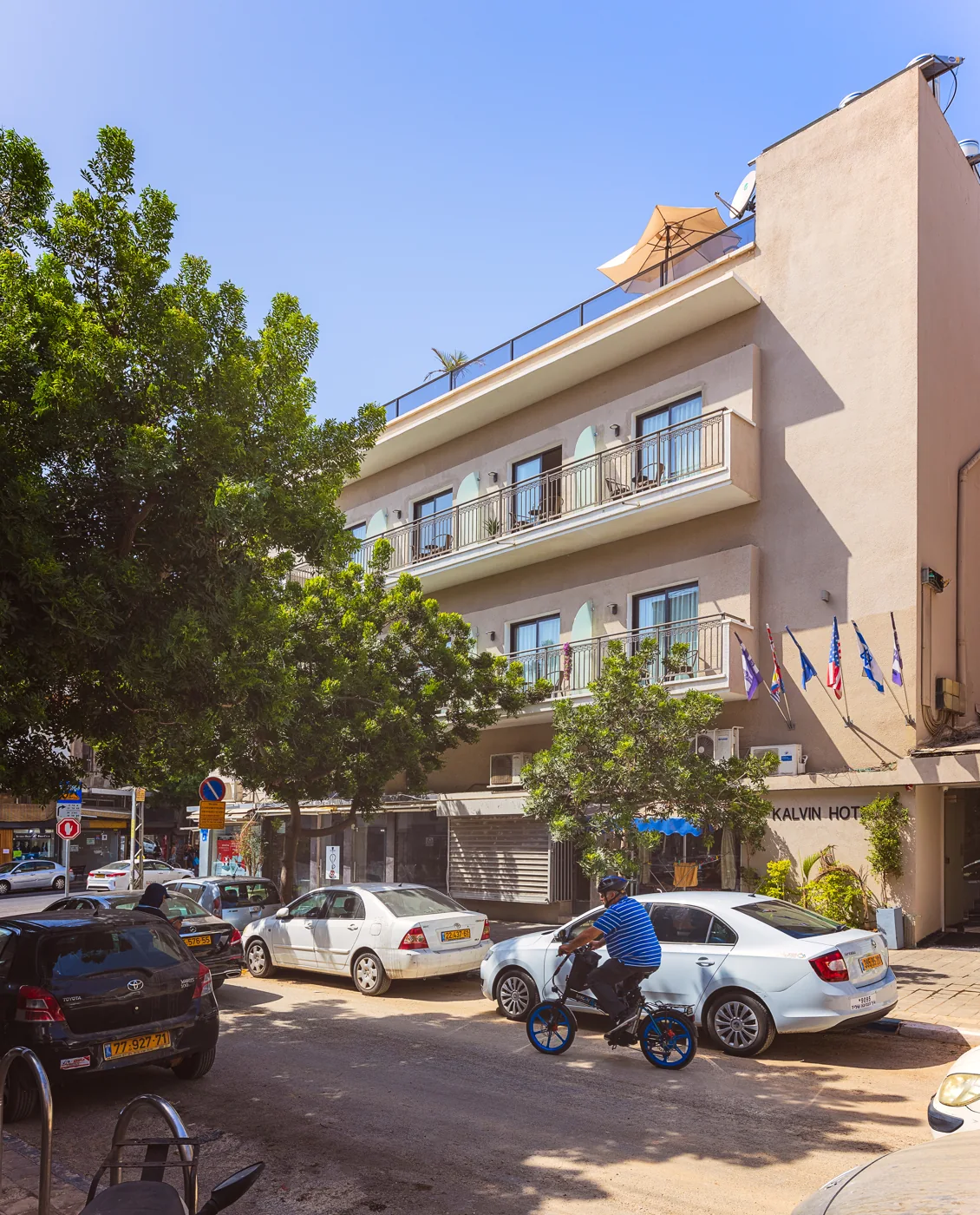 The Kalvin Boutique Hotel building on a tree-lined Tel Aviv street.