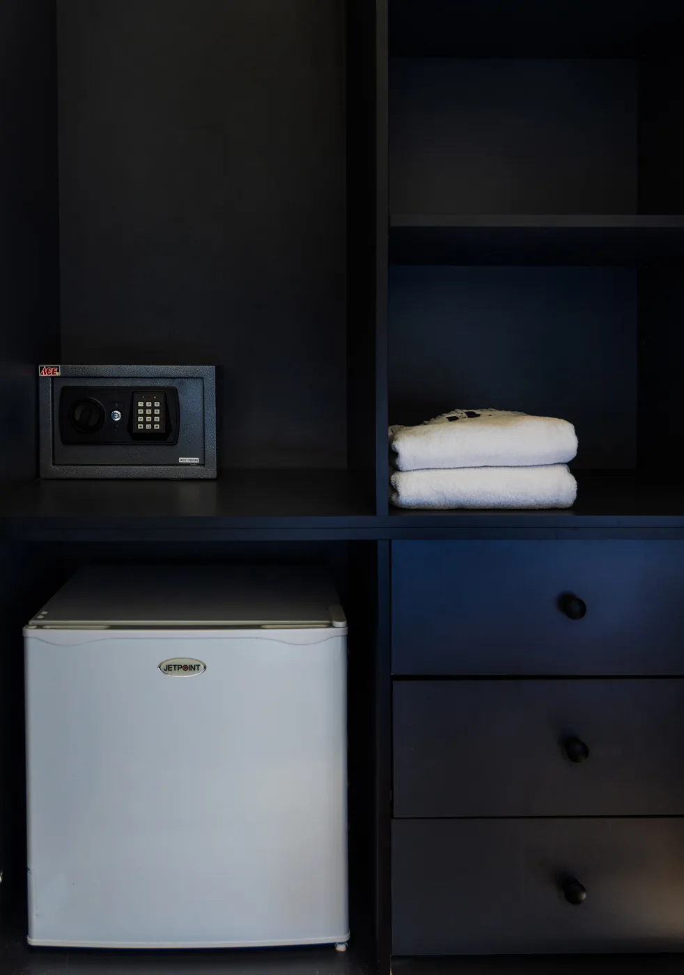 A compact kitchenette with a refrigerator and storage.